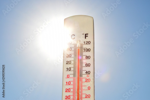 Quadro su tela Thermometer showing high temperature against bright sunny sky