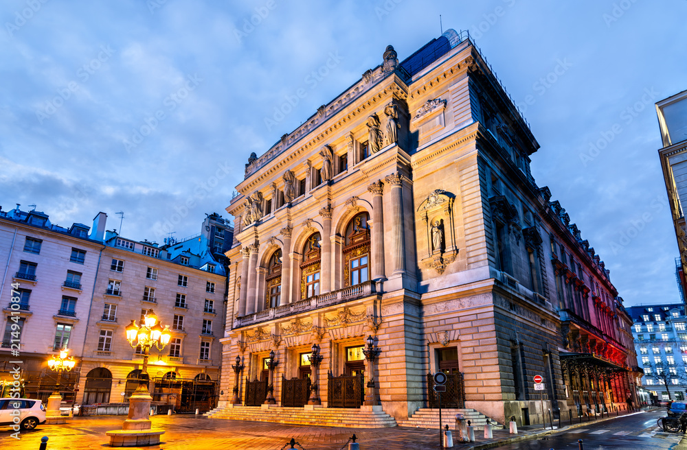 Fototapeta premium Exterior view of the illuminated classical facade of the Opera Comique theater building at dusk in Paris France.