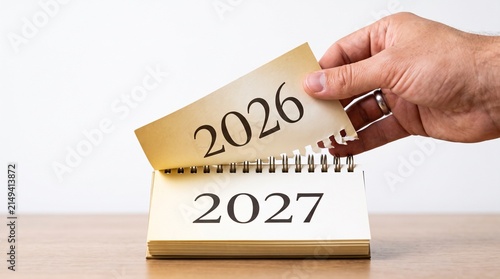 Hand reveals 2027 calendar page. New opportunities are coming. Paper desk calendar close up. Turning page for 2027 year. Starting new business period. Happy New Year, the start of the new year 