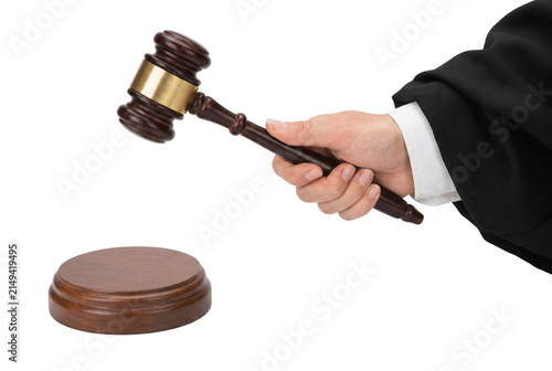 Obraz na plátně Hand of a judge holding a wooden gavel ready to strike