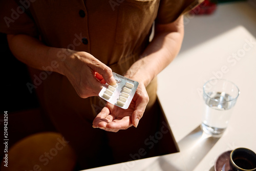Woman taking medication at home