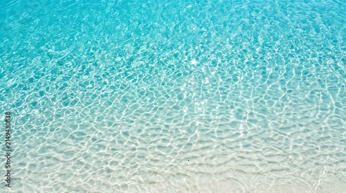 Sunlit turquoise water with bright caustics with caustics shimmering ripples wave