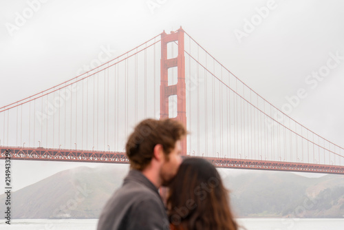 man kisses womans head couple golden gate bridge san francisco 