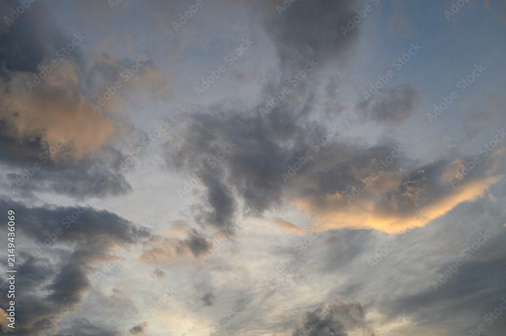Obraz premium Evening Sky with Partially Overcast Clouds, Golden Glow from Setting Sun, Darker Cloud Masses Above