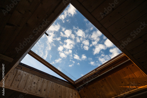 Open Skylight Framing Blue Sky and White Clouds