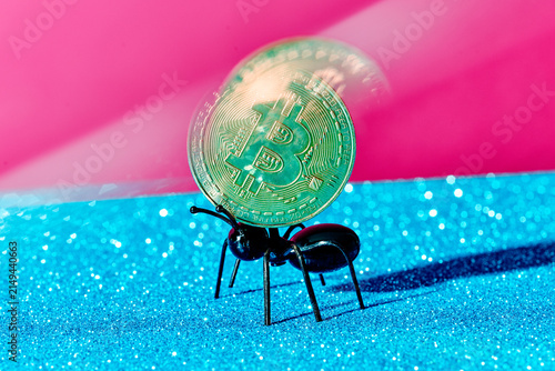 a toy ant carries a gold bitcoin, captured using shutter drag