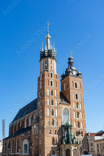 Quadro su tela St Marys Basilica facade and asymmetric brick towers under clear blue sky in Kra