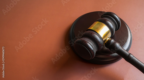 Obraz na plátně Wooden judge gavel with gold band on brown background with bokeh, court justice
