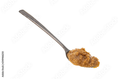Foto Metal spoon holding thick chunky peanut butter spread