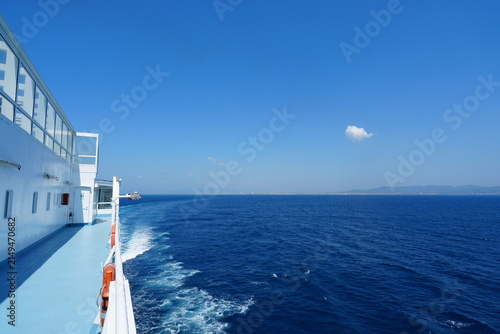 Foto peaceful ferry sailing on the ocean deck perspective with lifebuoys and windows in blue and white metal and plastic setting natural light clean background copy space editorial resource web