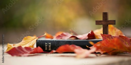 Holy Bible with wooden cross and vibrant autumn leaves