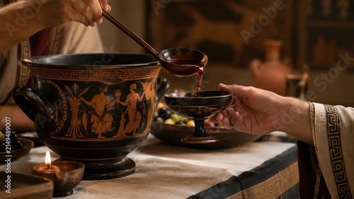 Wine poured from decorated krater during a ceremonial ancient Greek symposium feast
