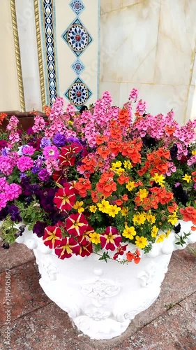 Colorful flower arrangement in white pot with decorative background  