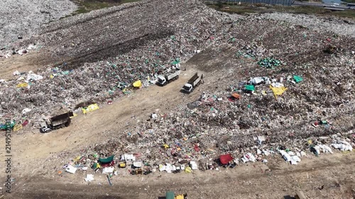 Trucks dumping garbage across a vast active waste landfill site