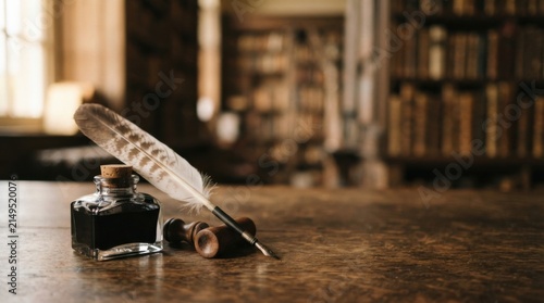 Quill pen and inkwell on wooden desk with copy space