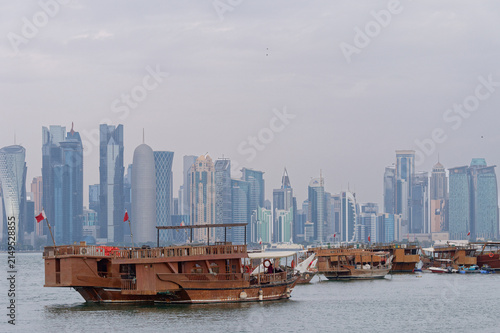 Foto Les bateaux en bois dans le port de Doha sont appelés des boutres, aujourd'hui utilisés pour des croisières panoramiques avec en fond les gratte-ciel de la ville