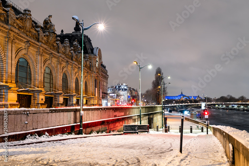 Quadro su tela Snowy view of Musee d'Orsay Museum and the Seine river embankment at night during winter in Paris, France