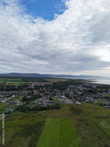 Dornoch is a picturesque Scottish town on Dornoch Firth, featuring a historic cathedral from 1224, ancient castle, blue skies, and beaches.
