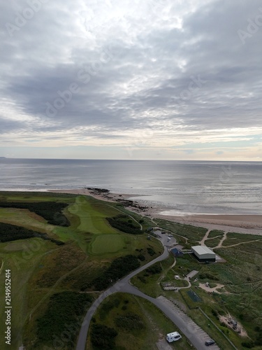 Dornoch is a historic Scottish coastal town beside Dornoch Firth, glowing at sunset with golden skies, sea views, sandy shores, and heritage.