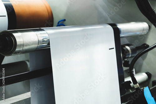 Large industrial offset printing machine prints image on packaging film. tech industrial technology background