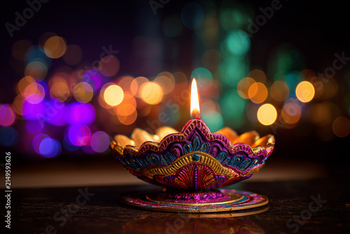 Colorful Diya Oil Lamp with Glowing Flame and Festive Bokeh Lights for Diwali, ai generated