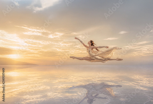 Elegant Ballerina Performing Above Reflective Salt Flats at Golden Sunrise	
