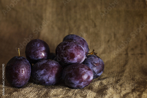 Foto Fresh prune plums with water drops on rustic burlap background with copy space