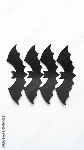 Row of black paper bat cutouts arranged in a playful pattern for Halloween decorations and seasonal campaigns