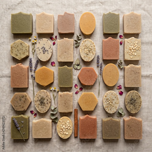 Overhead flat lay of a collection of unlabeled artisanal soaps on linen texture