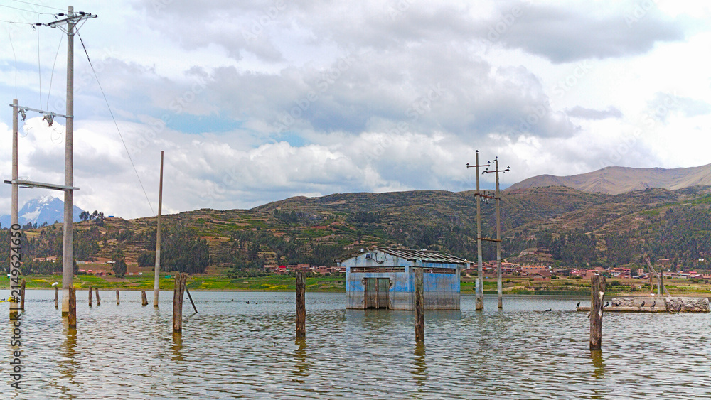 Fototapeta premium Estación eléctrica rural abandonada e inundada en una laguna en el atardecer