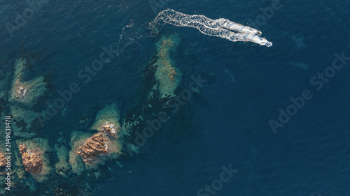 Aerial view of jet ski leaving white wake above rocky seabed in the Mediterranean Sea