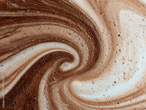 Close-up of latte art, intricate patterns in milk foam resembling a flower or dandelion seed, warm colors light brown, dark brown, natural soft lighting, macro photography style - AI-Generated