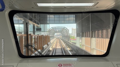 First person point of view of a light rail train driving on elevated tracks in the city.