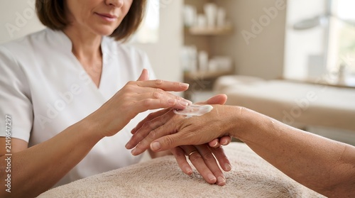 Practitioner Applying Cream During Hand Care Treatment