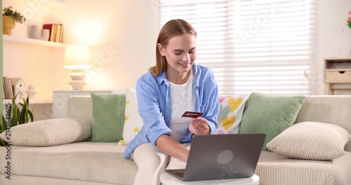 Online store. Woman with credit card using laptop at white table indoors