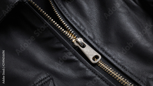 Macro detail of a metal zipper on a black leather jacket