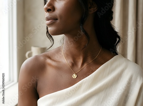 Close-up of woman wearing delicate gold pendant necklace, quiet luxury jewelry