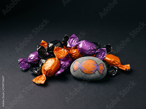 Pile of wrapped Halloween candies with one being a painted rock
