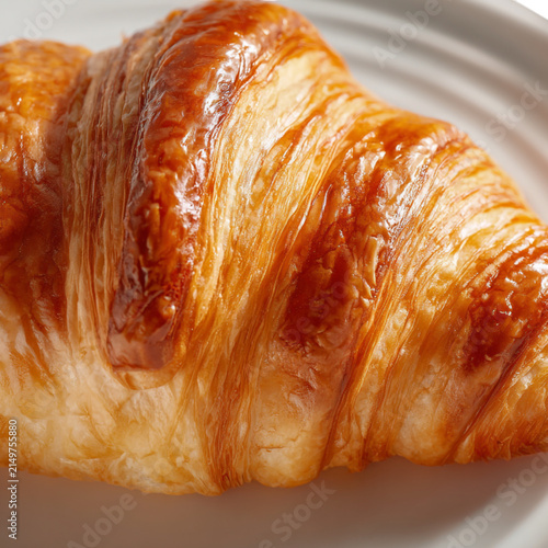 Картината върху платно Golden brown flaky croissant closeup
