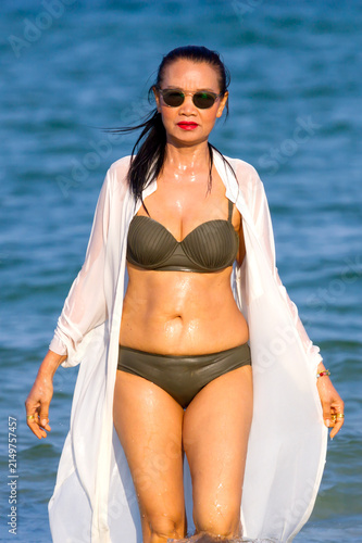Woman with brown bikini walk on beach