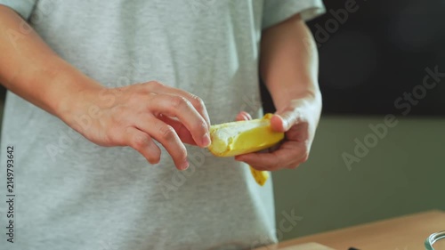 Close-up of woman hands peeling a banana.