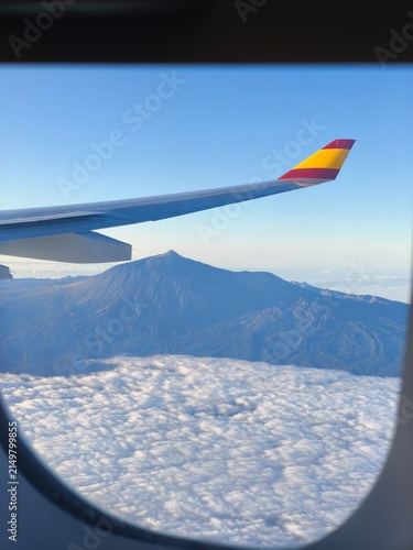 Photography A dense layer of fluffy white clouds completely covers the base of the mountain and the valleys—a meteorological phenomenon very typical of the Canary Islands known as a sea of ​​clouds