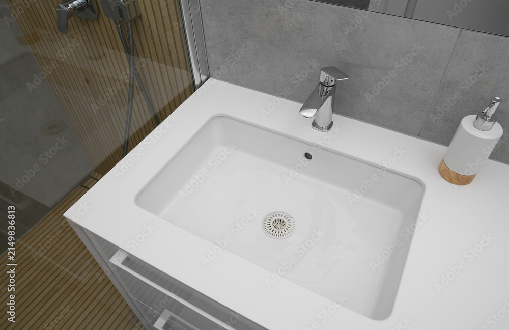 Fototapeta premium A white washbasin with a nickel-plated washbasin tap in the bathroom