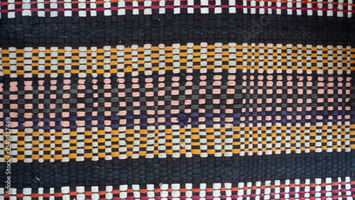 Traditional woven fabric texture with colorful geometric stripes.