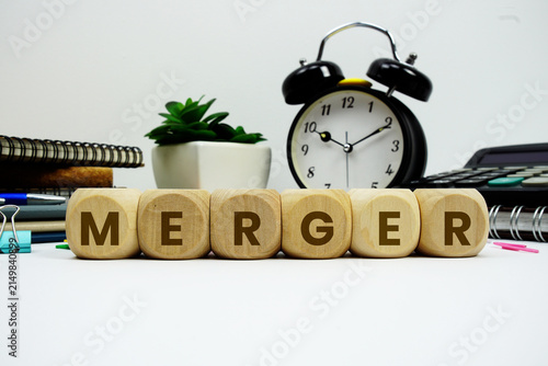 Bild auf Leinwand MERGER alphabet letters with alarm clock and calculator on white background