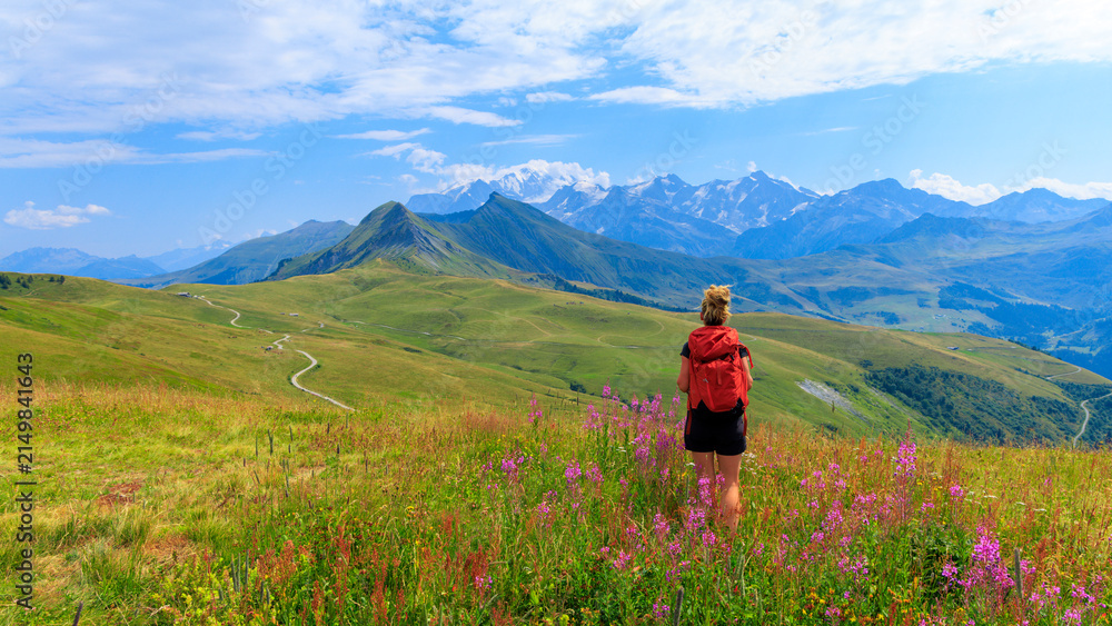 Fototapeta premium Woman Hiker Standing in Alpine Meadow Enjoying Alps Mountain View, Mont blanc, France in summer