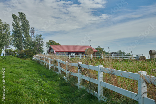 Rural Farm with White Fence and Hay Bales in Hokkaido, Japan