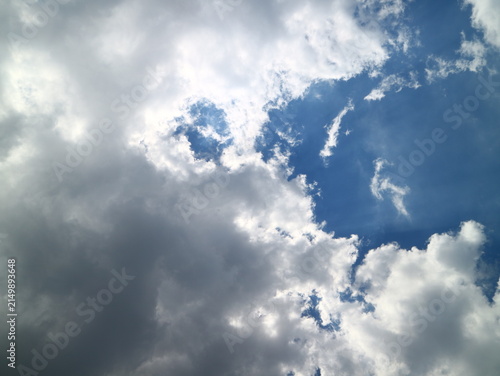 Canvas Print Wide low angle view of bright white clouds floating across a deep blue sky on a clear sunny day