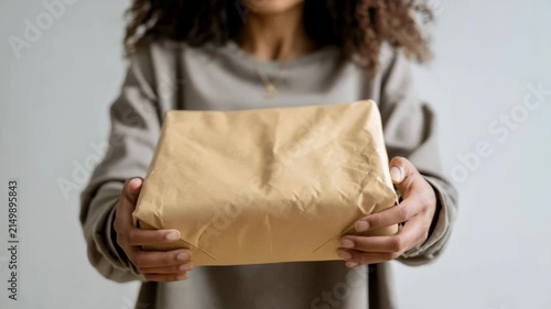 Woman hands holding brown paper package delivery