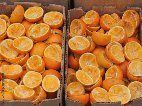 Canvastavla Top view of squeezed orange halves piled up inside cardboard boxes after making